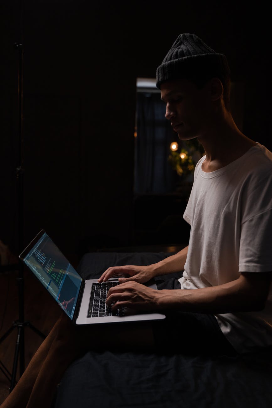 man in white crew neck t shirt using macbook pro